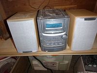 Front view of Kenwood stereo main unit flanked by two speakers.