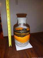 Side view of vase next to measuring tape showing height of about 10 inches