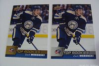 Front view of two Zach Werenski NHL rookie cards in Columbus Blue Jackets uniform, showing action shot and team logo.