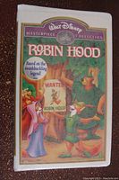 Front cover of Robin Hood VHS tape with colorful illustrated cover showing Disney characters and tree background.