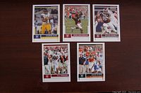 Photo showing five NFL rookie cards arranged on a dark surface. Cards depict players Kareem Hunt, DeDe Westbrook, Myles Garrett, O.J. Howard, and David Njoku in game action.