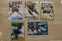 Photo showing 5 NHL hockey cards from various brands featuring players such as Mario Lemieux and Patrick Roy, all in Near Mint condition
