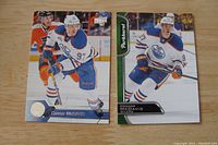 Front of two hockey cards featuring Connor McDavid in Edmonton Oilers uniform, one Upper Deck Series 2 and one Parkhurst card.