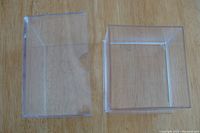 Top view of open empty clear plastic card holder box showing separate lid and base