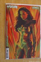 Front of comic showing Gal Gadot as Wonder Woman in detailed armor with red/orange background.