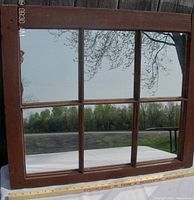 Front view of the 6 pane mirrored wooden window frame showing the reflective glass panes and part of the wooden frame with measuring tape below.