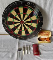 Photo showing the vintage National Darts Federation of Canada dart board with two sets of darts and accessories.