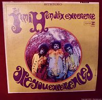 Front cover of The Jimi Hendrix Experience "Are You Experienced" vinyl LP showing band members and title in purple on yellow background.