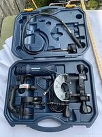 MasterCraft rotary tool with router base and flexible shaft inside blue plastic carrying case, showing tool and attachments secured.