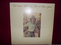 Front cover of the Paul Simon LP "Still Crazy After All These Years" showing the photo of Paul Simon on a balcony.
