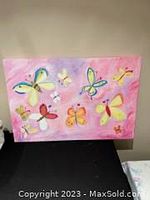 Front view of colorful butterfly painting on canvas with pink background