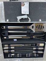 Open BBQ tool case showing the stainless steel utensils secured with black straps inside foam padding.