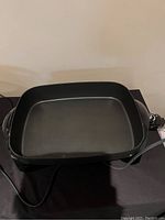 Black Rival electric skillet showing non-stick interior and temperature control cord.