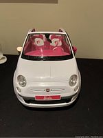 Front view of the white Fiat 500 Barbie Edition toy car highlighting front details and pink interior seats