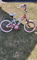 Full view of the Tech Team Blossom kids bicycle placed on grass, showing the bike's frame, wheels, seat, and handlebar grips.