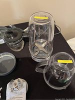 Set of Magic Bullet blender cups and blades showing primary components with attached blades and lids.