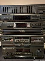 Close-up view of the stacked Technics stereo system components including graphic equalizer, tuner, CD player, cassette deck, and stereo amplifier, showing brand and model details.
