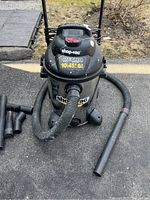 Front view of the Shop-Vac Ultra wet/dry vacuum with hose and nozzles laid out showing condition and accessories.