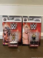 Front view of two brand new and sealed WWE Nano MetalFigs figures: Ultimate Warrior and Brock Lesnar in packaging.
