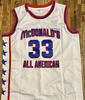 Front view showing the McDonald's All-American designation, number 33 in blue with red outline, and side star accents on red stripes.