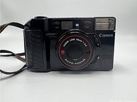 Front view of the Canon Sure Shot AF35M II 35mm film camera showing lens, built-in flash, and strap attachment.
