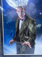 Close-up photo of the 8x10 signed photo of Matt Smith as the Eleventh Doctor in green jacket and bow tie, showing autograph.
