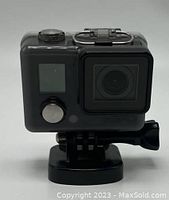 Front view of GoPro HERO camera inside transparent waterproof case showing front LCD screen, button, and lens.