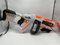 Side view of white and orange NERF Ultra One motorized blaster featuring the drum magazine and dart storage on the stock.