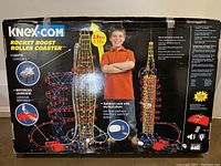 Front side of original K'NEX Rocket Boost Roller Coaster box showing assembled coaster with kid model, key features like motorized launcher, lights and height indication (3.9 ft / 1.14 m)