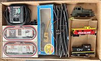 Photo of boxed additional train cars, track pieces, and power pack in a cardboard box