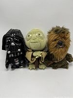 Front view of all three plush dolls showing Darth Vader, Yoda, and Chewbacca