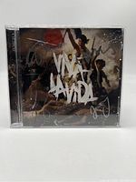 Front of the CD jewel case showing Viva La Vida or Death and All His Friends album cover with silver autographs from band members visible.