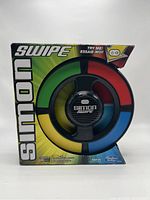 Front view of Simon Swipe game in original packaging, showing colorful circular design and brand name.