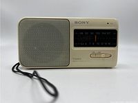 Front view of the white Sony ICF-390 radio showing speaker, tuning window, band selector, and Sony logo.