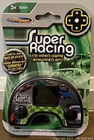 Front of sealed Super Racing LCD video game package showing the handheld device with racing car graphics on screen, black controls, and green-white packaging design.