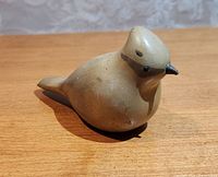 Front view of Cedar Waxwing wood carving showing bird's head and rounded body details.