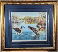 Framed print showing two geese at lakeside with autumn trees.