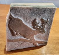 Front view of bas-relief sculpture showing a deer carved in Ontario marble.