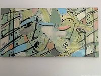 Front view of the large colorful abstract painting showing two faces and signature.