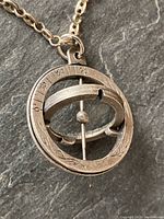Close-up front view of pendant showing degree scale and rotating bar mechanism