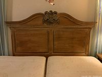 Front view of Lexington queen-size wooden headboard showing its carved floral top and two inset panels.