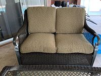 Front view of two cushion seat love seat with nautical rope woven style and metal frame.