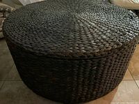 Front angle showing the round woven rattan surface and side of the coffee table.