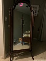 Front view of the Thomasville standalone floor mirror showing the full mirror surface and decorative wooden frame with carved design and turned posts on the sides.