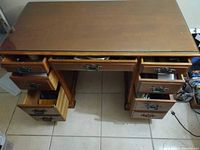 Full view of the vintage wood desk with glass top, open drawers showing storage space and metal handles