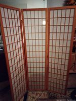 Three panel natural wood folding room divider with grid overlay and white paper or fabric insert.