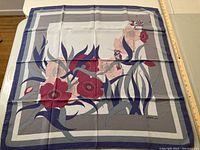 Floral silk scarf in gray and lilac tones with red and pink flowers, laid flat to show design and condition