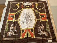 Front view of one silk scarf showing hunting dogs, brass horns, and detailed equestrian scenes in a brown color scheme with red and green accents.