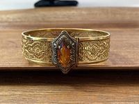 Front view of Art Deco filigree bracelet with amber-colored marquise stone at center.
