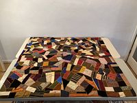 Full view of quilt laid flat on table exhibiting overall size and patchwork design